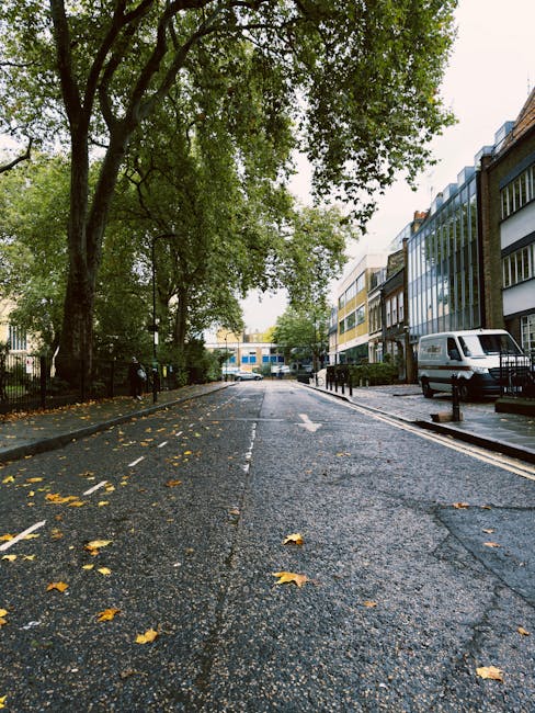 The image shows the exterior of a building with a white facade and a wooden doorway, labeled with a sign above the entrance that reads 'Abbey Road Studios.' On either side of the entrance, there are t